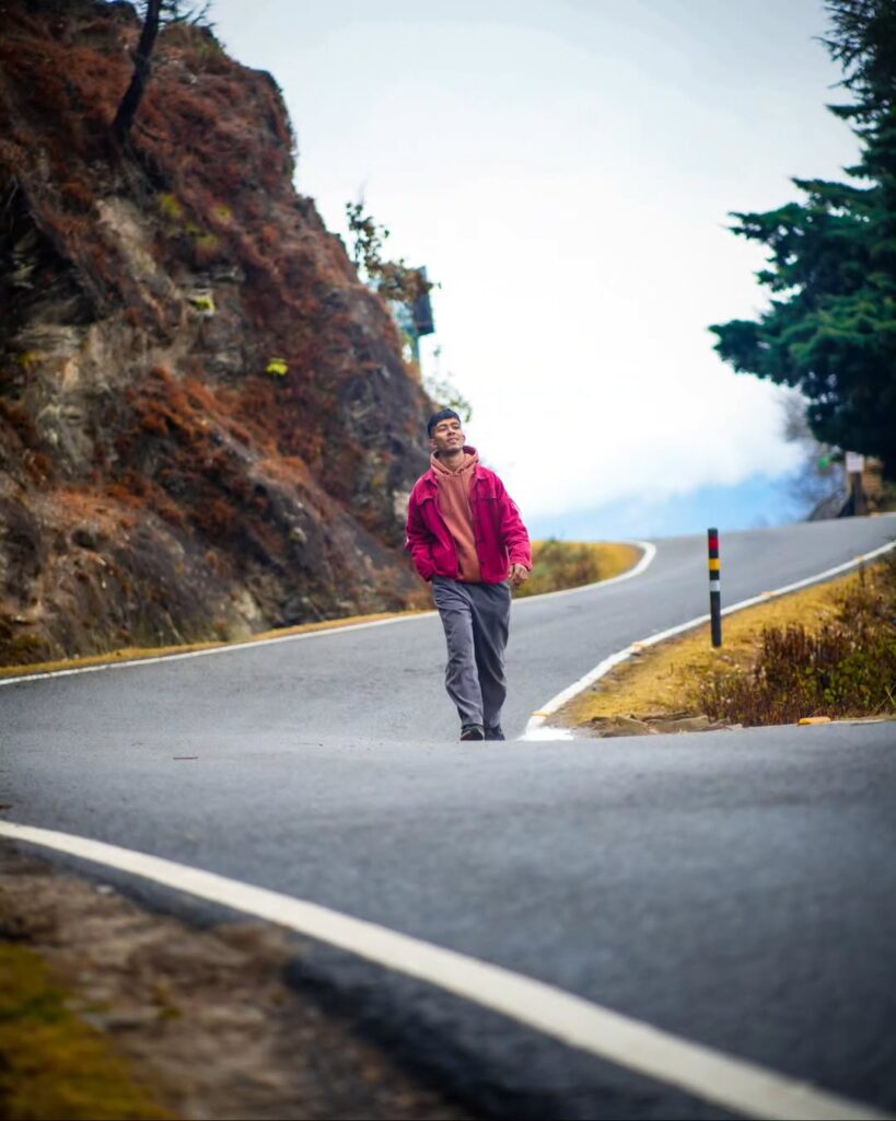 A man standing peacefully amidst a scenic mountain landscape, embracing a spiritual moment in nature.